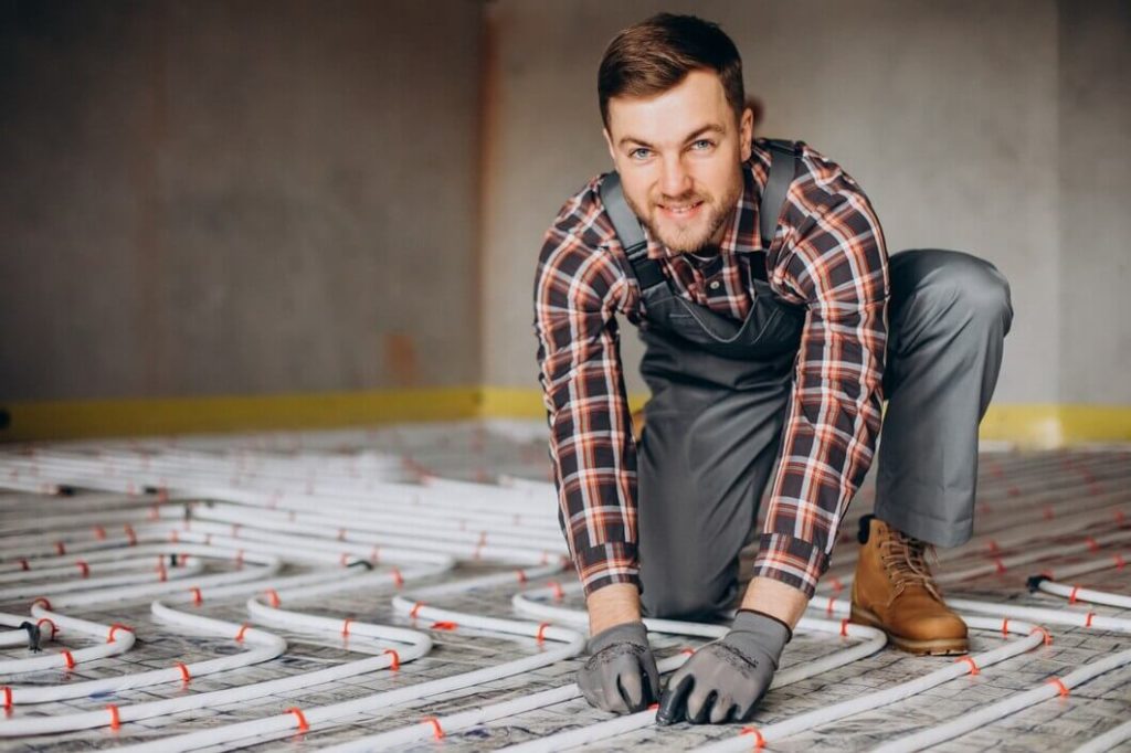 Technicien installant un plancher électrique chauffant